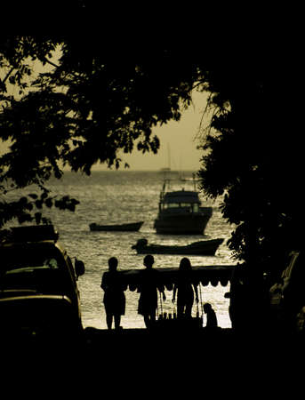 Three women in silhouette walking to the beach at Playa Hermosa in Costa Rica.の写真素材