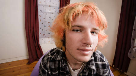 Closeup of a Young man with Bright Hair in a Bare Roomの写真素材