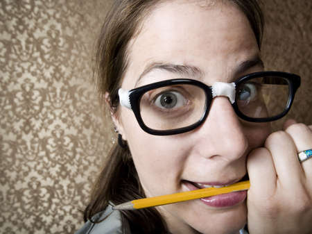 Nervous nerdy Woman Chewing on a Yellow Pencilの写真素材