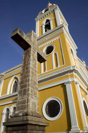 Stone cross next to the yellow cathedral in central Granada Nicaraguaの写真素材