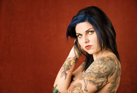 Pretty young woman with many colorful tattoosの写真素材