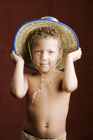Little boy with curly hair and blue eyes in a sheriff hatの写真素材