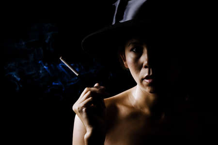 Mysterious woman in shadows wearingの写真素材