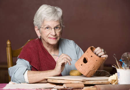 Senior woman working on a clay sculptureの写真素材
