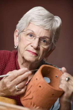 Senior woman working on a clay sculptureの写真素材