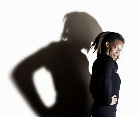 African American woman with dreadlocks against a white wallの写真素材