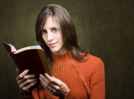 Pretty woman in orange sweater with Bible