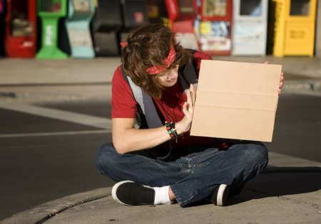 Young Man on Street Corner with Blank Cardboard Sign
