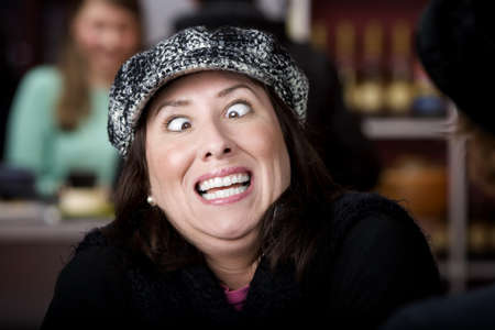 Hispanic woman in hat crossing her eyesの写真素材