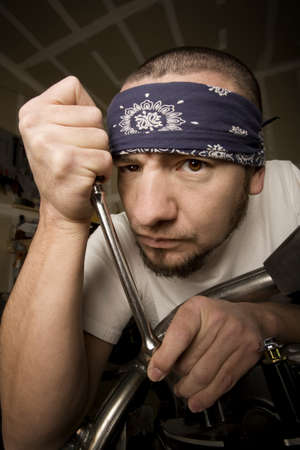 Hispanic mechanic working on a chopper style motorcycleの写真素材