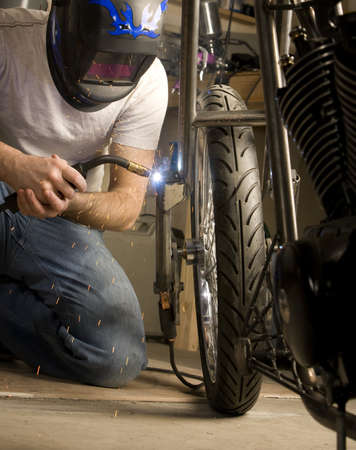 Welder working on the metal fork of a motorcycleの写真素材