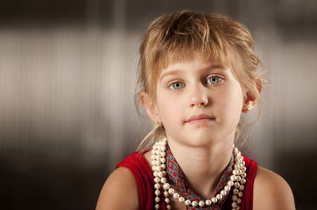 Cute young girl with big eyes in dress-up clothesの写真素材