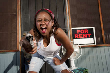 African American woman with a gun on her front porchの写真素材
