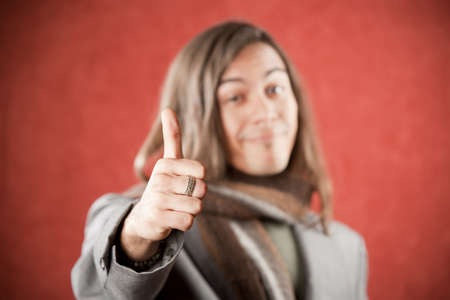 Closeup Portrait of a Handsome Young Man Making a Thumbs Up Gestureの写真素材