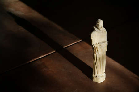 Wooden Statue of St. Francis in Afternoon Light with Shadowの写真素材