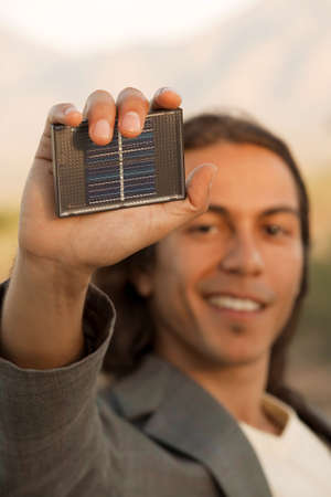 Handsome young mixed race man with small solar panelの写真素材