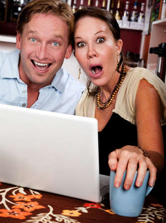 Attractive couple in a coffee house with laptop computerの写真素材