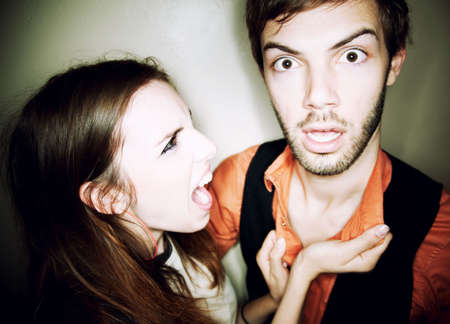Young woman screaming at hapless bearded manの写真素材