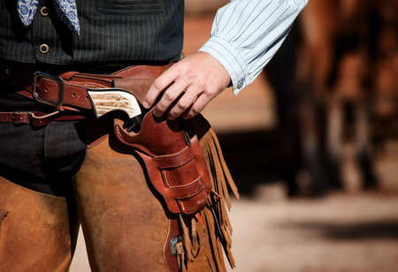 Closeup of cowboy with chaps, gun and leather beltの写真素材