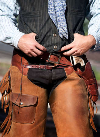 Closeup of cowboy with chaps, guns and leather beltの写真素材