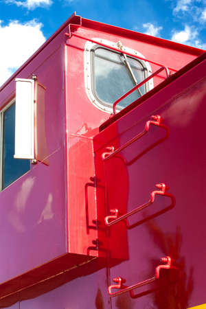Detail of red train caboose against blue skyの写真素材