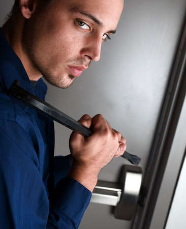 Burglar breaking into a building using crowbarの写真素材