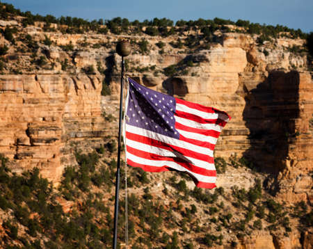 Fluttering American Flag in front of Grand Canyon Ridgeの写真素材