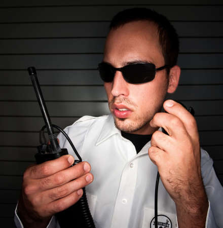 Security patrol officer talking into a modile radioの写真素材