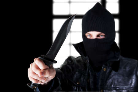 Young male criminal brandishing knife with large bladeの写真素材