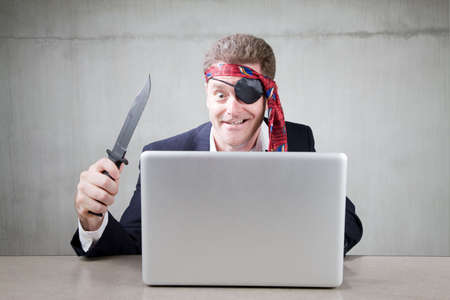 Eccentric business man acting as Internet pirateの写真素材