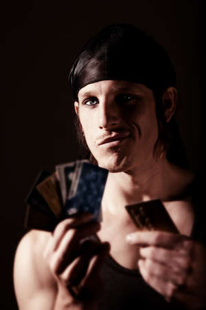 Indentity thief holding many stolen credit cardsの写真素材