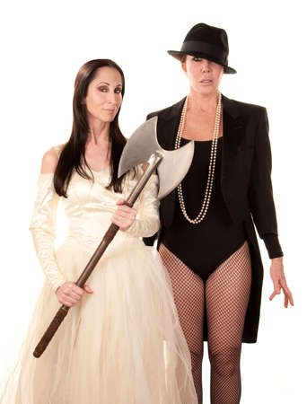 Two women dressed as traditional bride and groom with axeの写真素材