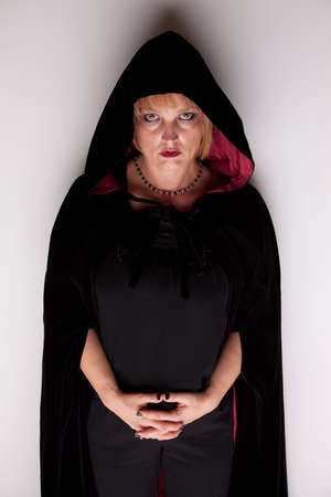 Female witch in dark robe with hoodの写真素材