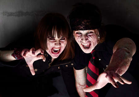 Male and female bloody zombies reaching outの写真素材
