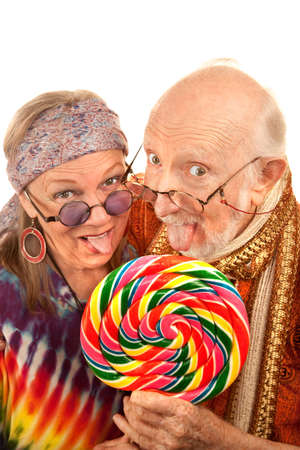 Portrait of hippie seniors licking a large lollipopの写真素材