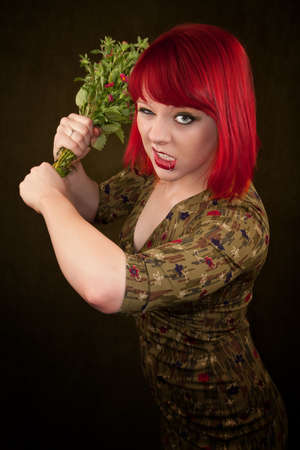 Pretty punky girl with brightly dyed red hair and flowersの写真素材