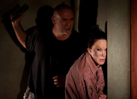 Woman in hallway with bruise on her cheek with menacing man