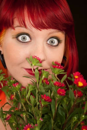 Pretty punky girl with brightly dyed red hair and flowersの写真素材