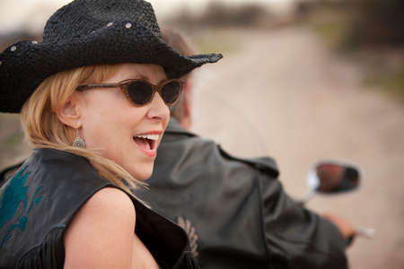 Fun couple riding on a motorcycle outsideの写真素材