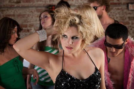 Lovely blond with hands running through her hair at a partyの写真素材