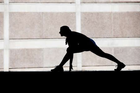 Single woman stretches before she goes for run.の写真素材