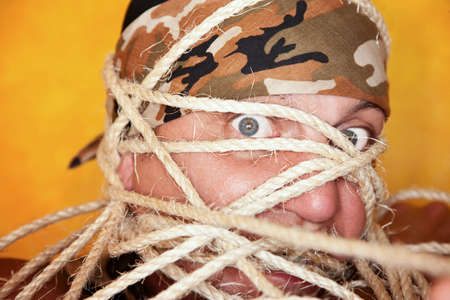 Angry man bound up in many ropesの写真素材