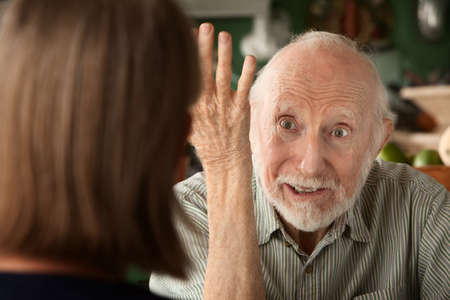 Senior couple at home in kitchen focusing on angry manの写真素材