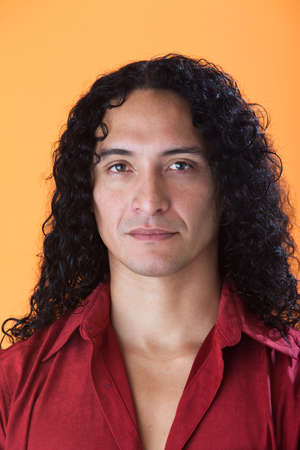 Handsome man with strong features and long curly hairの写真素材