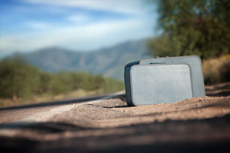 Suitcases by the side of a desert roadの写真素材