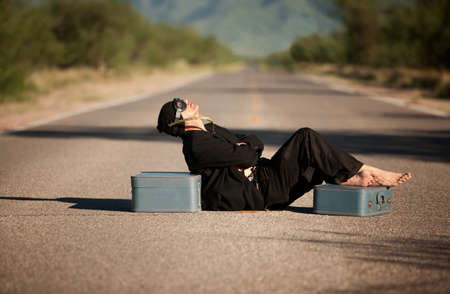 Strange indigenous man in the middle of a road with suitcasesの写真素材