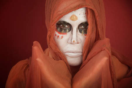 A lady with dramatic All Souls Day makeup and a orange scarf