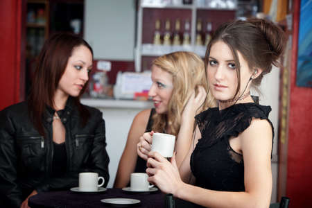 Gorgeous teenaged girl listening to music while her friends converseの写真素材