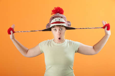 Young Caucasian woman plays with her sock monkey cap