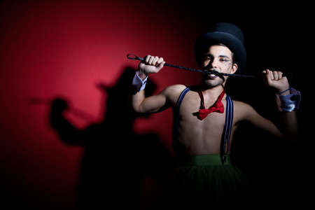 Performer in top hat biting leather whipの写真素材